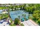 Aerial view of well-maintained tennis and bocce ball courts, surrounded by lush greenery and palm trees in a vibrant community setting at 780 Mystic Hill Ct, Kissimmee, FL 34759