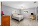 Well-lit bedroom featuring wood-look flooring, ceiling fan, and double-paned windows at 8608 Se 141St Street Rd, Summerfield, FL 34491