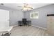 Bright bedroom featuring wood-look floors, gray walls, ceiling fan, and work space by window at 8608 Se 141St Street Rd, Summerfield, FL 34491