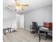 Bright bedroom with modern ceiling fan, wood-look floors, gray walls, and a dedicated workspace at 8608 Se 141St Street Rd, Summerfield, FL 34491