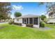 Beautiful home with manicured landscaping featuring a lush green lawn, trimmed hedges, and mature trees at 8608 Se 141St Street Rd, Summerfield, FL 34491