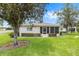Beautiful home featuring a lush green lawn, manicured hedges, and mature trees in quiet community at 8608 Se 141St Street Rd, Summerfield, FL 34491