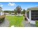 Well-maintained front lawn with a tree in the center, complemented by lush landscaping and neighboring homes at 8608 Se 141St Street Rd, Summerfield, FL 34491