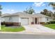 Charming single-story home with a well-manicured lawn, decorative driveway, and inviting front door at 8608 Se 141St Street Rd, Summerfield, FL 34491