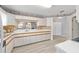 An open kitchen features white cabinets, wood-look floors, and a view to the dining room at 8608 Se 141St Street Rd, Summerfield, FL 34491