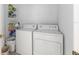Utility area features white washer and dryer with shelving for storage at 8608 Se 141St Street Rd, Summerfield, FL 34491