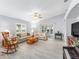 Bright living room with neutral paint, ceiling fan, and view of screened-in lanai at 8608 Se 141St Street Rd, Summerfield, FL 34491