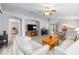 Open-concept living room showcasing arched doorways, white sofas, and an entertainment center at 8608 Se 141St Street Rd, Summerfield, FL 34491