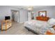 Spacious main bedroom with wood-look flooring, a TV stand, and access to an ensuite bathroom at 8608 Se 141St Street Rd, Summerfield, FL 34491