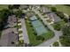 Serene community featuring a pool, tennis court, and well-maintained landscaping surrounded by lush greenery at 8705 Village Green Blvd, Clermont, FL 34711