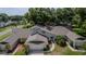 Charming two-story home with a well-maintained lawn, mature landscaping, and an attached two-car garage at 8705 Village Green Blvd, Clermont, FL 34711