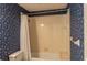 Bathroom featuring blue floral wallpaper, a bathtub and shower combination, and tile flooring at 8705 Village Green Blvd, Clermont, FL 34711