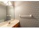 Powder room with patterned wallpaper, a vanity with mirror, and essential fixtures at 8705 Village Green Blvd, Clermont, FL 34711