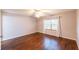 Comfortable bedroom featuring wood floors, neutral paint, and a bright window at 8705 Village Green Blvd, Clermont, FL 34711