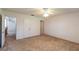 A well-lit bedroom with neutral carpet and a ceiling fan; access to a closet and other rooms at 8705 Village Green Blvd, Clermont, FL 34711