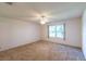 A well-lit bedroom featuring neutral carpet, fresh paint, and a window that offers natural light at 8705 Village Green Blvd, Clermont, FL 34711