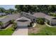 Charming two-story home with a well-maintained lawn, mature landscaping, and an attached two-car garage at 8705 Village Green Blvd, Clermont, FL 34711
