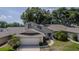 Charming home featuring a two-car garage, a well-manicured lawn, and mature trees offering plenty of shade at 8705 Village Green Blvd, Clermont, FL 34711