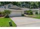 Lovely home with a spacious driveway, well-maintained lawn, and beautiful landscaping at 8705 Village Green Blvd, Clermont, FL 34711
