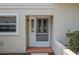 Close-up of the decorative front door with sidelights and a storm door, situated on a tiled landing at 8705 Village Green Blvd, Clermont, FL 34711