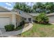 Charming home featuring a well-maintained lawn, decorative shrubbery, and a walkway to the front door at 8705 Village Green Blvd, Clermont, FL 34711