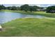 Scenic view of the lush golf course and tranquil lake, perfect for outdoor recreation at 8705 Village Green Blvd, Clermont, FL 34711