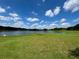 Picturesque golf course with a serene lake and a vibrant green fairway on a sunny day at 8705 Village Green Blvd, Clermont, FL 34711