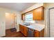 Kitchen area showcasing wood cabinets, a stainless steel dishwasher, a double sink, and a window view at 8705 Village Green Blvd, Clermont, FL 34711