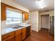Functional kitchen featuring wood cabinets, laminate countertops, and stainless steel appliances at 8705 Village Green Blvd, Clermont, FL 34711