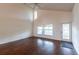 Living room showcasing wood floors, high ceilings, and lots of natural light from large windows at 8705 Village Green Blvd, Clermont, FL 34711