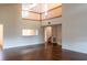 Spacious living room with wood floors, high ceilings, balcony view, and connection to the kitchen area at 8705 Village Green Blvd, Clermont, FL 34711