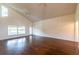 Living room featuring wood floors, high ceilings, and a wall of windows for natural light at 8705 Village Green Blvd, Clermont, FL 34711