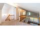 Loft area featuring neutral carpet, fresh paint, wood railing, and direct access to the living room at 8705 Village Green Blvd, Clermont, FL 34711