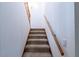Carpeted stairway with a wooden handrail leading to the upper level at 8705 Village Green Blvd, Clermont, FL 34711