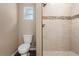 Modern bathroom with a tiled shower and a separate toilet, plus small window at 919 Cr 482C, Lake Panasoffkee, FL 33538