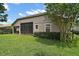 View of home's backyard, showcasing the screened-in lanai, green lawn, and tidy landscaping at 926 Wood Briar Loop, Sanford, FL 32771