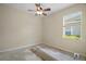 A neutral bedroom is getting new flooring, with a ceiling fan and natural light at 926 Wood Briar Loop, Sanford, FL 32771
