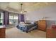 Comfortable bedroom with neutral carpet, tray ceiling, ceiling fan, and large window at 926 Wood Briar Loop, Sanford, FL 32771