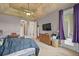 Comfortable main bedroom featuring tray ceilings, ceiling fan, television, and access to the outside at 926 Wood Briar Loop, Sanford, FL 32771