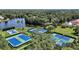 Aerial view of well-maintained tennis courts surrounded by lush greenery and trees at 926 Wood Briar Loop, Sanford, FL 32771