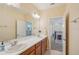 Bathroom featuring double sinks, vanity with cabinets, large mirror, and great natural lighting at 1539 Osprey View Dr, Apopka, FL 32703