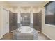 Stylish bathroom with a soaking tub surrounded by decorative gray tiling and a glass door shower at 1539 Osprey View Dr, Apopka, FL 32703