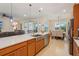Open kitchen featuring a large island with a stainless steel sink, wood cabinets, and seamless flow into the dining area at 1539 Osprey View Dr, Apopka, FL 32703