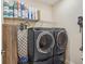 A laundry room with black appliances and shelving with paper towel and toilet paper at 1539 Osprey View Dr, Apopka, FL 32703