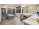 Stylish main bathroom features a soaking tub, tiled shower, dual sinks, and wood-look tile flooring at 1539 Osprey View Dr, Apopka, FL 32703