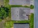 Aerial view of a single-Gathering home featuring a gray roof, green lawn, and proximity to neighboring houses at 1016 Eagles Lndg, Leesburg, FL 34748