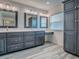 Well-lit bathroom featuring a double vanity with grey cabinets, three mirrors, and modern fixtures at 1016 Eagles Lndg, Leesburg, FL 34748