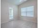Bedroom with white tile flooring, an exit door, and window with blinds at 1016 Eagles Lndg, Leesburg, FL 34748
