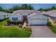 Charming single-story home with a well-manicured lawn, beautiful landscaping, and a brick-paved driveway at 1016 Eagles Lndg, Leesburg, FL 34748