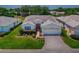 Aerial view of a well-manicured home with a brick driveway, landscaping, and a red front door at 1016 Eagles Lndg, Leesburg, FL 34748